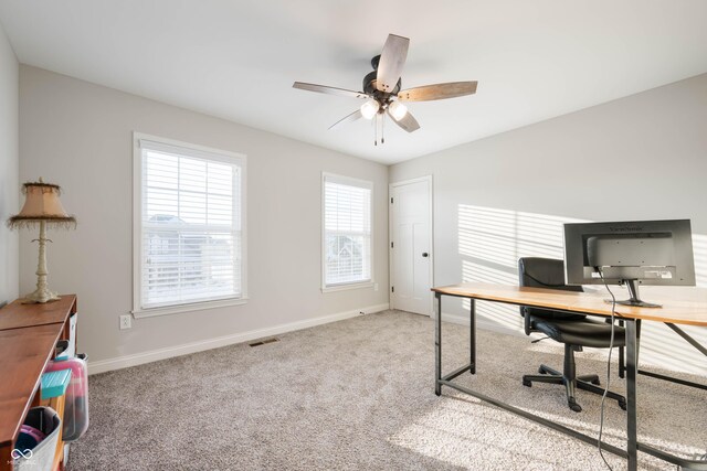 carpeted office space with ceiling fan