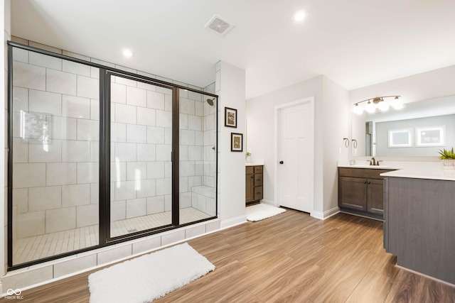 bathroom featuring a shower with shower door, vanity, and hardwood / wood-style flooring