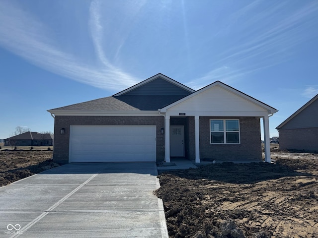 view of front facade with an attached garage, driveway, and brick siding