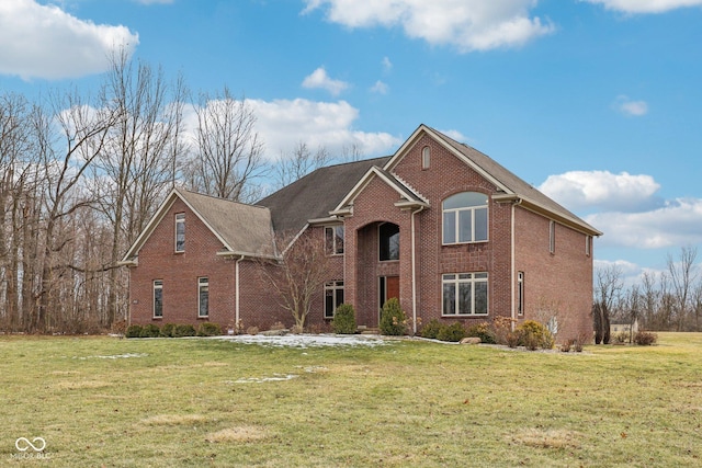 traditional-style house featuring a front yard and brick siding