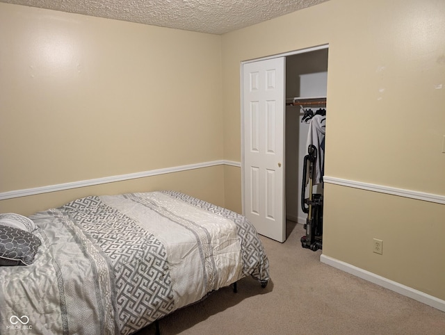 bedroom with a textured ceiling, light colored carpet, and a closet