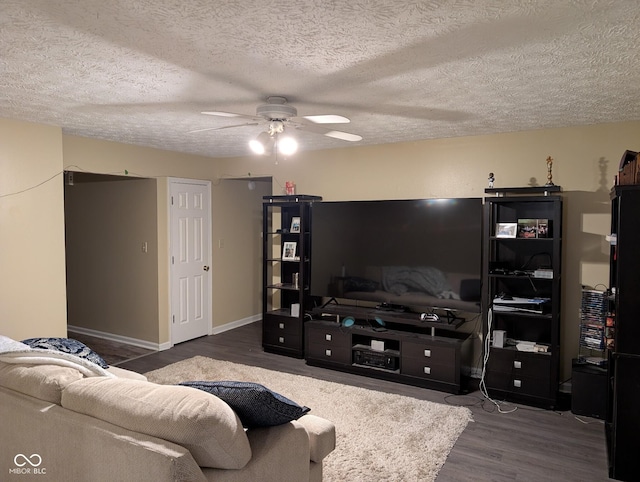 living room with ceiling fan, dark hardwood / wood-style floors, and a textured ceiling