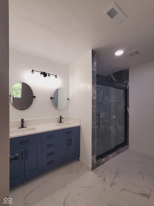 bathroom featuring vanity, an enclosed shower, and a textured ceiling