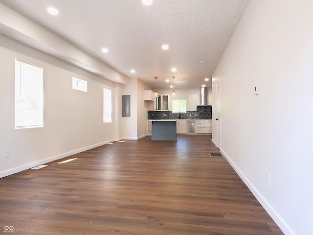 unfurnished living room with dark hardwood / wood-style flooring and electric panel