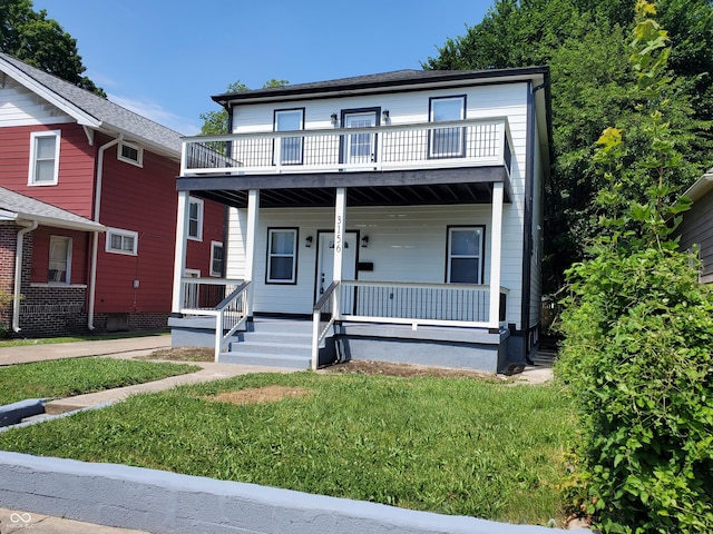 view of front of house featuring covered porch, a front yard, and a balcony