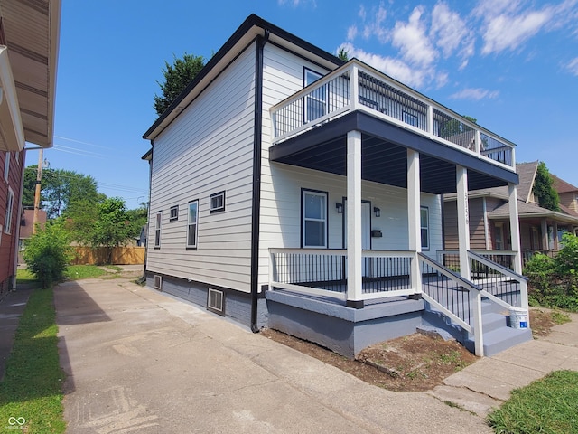 view of front of house with a balcony and covered porch