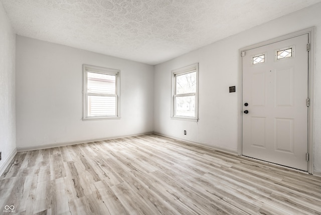 entrance foyer with a textured ceiling and light hardwood / wood-style flooring