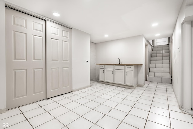 kitchen with white cabinetry, sink, and light tile patterned floors