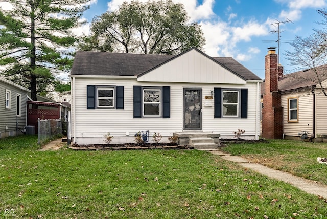 bungalow with cooling unit and a front yard