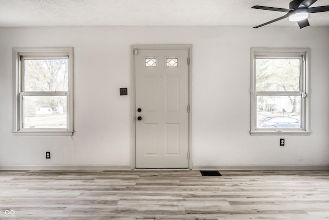 foyer entrance featuring a textured ceiling, plenty of natural light, and ceiling fan