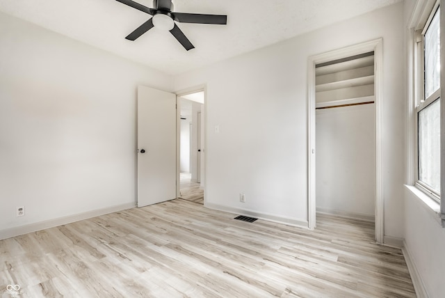 unfurnished bedroom with ceiling fan, light wood-type flooring, and a closet