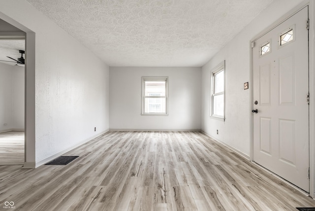 entryway featuring ceiling fan, a textured ceiling, and light wood-type flooring