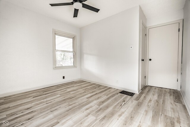 spare room with light wood-type flooring and ceiling fan