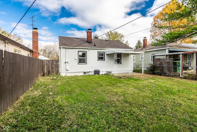 back of property featuring a lawn and central air condition unit