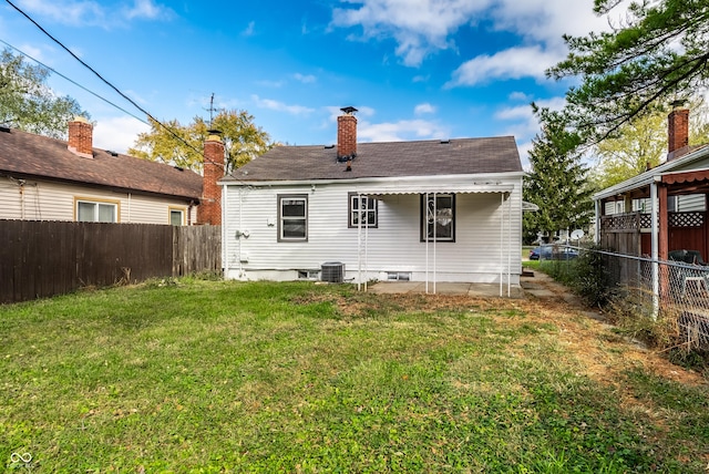 back of property featuring cooling unit and a lawn