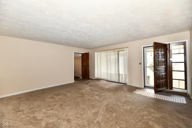 carpeted spare room with a textured ceiling