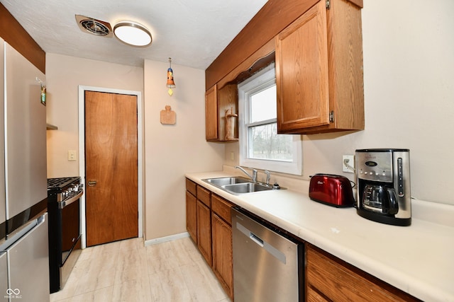 kitchen with decorative light fixtures, sink, and appliances with stainless steel finishes