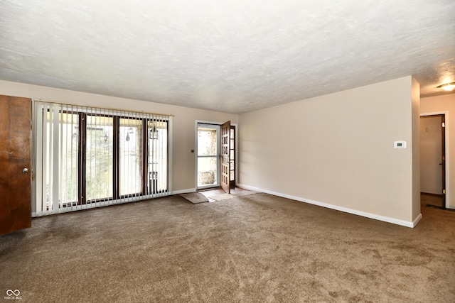 carpeted empty room featuring a textured ceiling