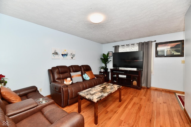 living room featuring a textured ceiling and light hardwood / wood-style flooring