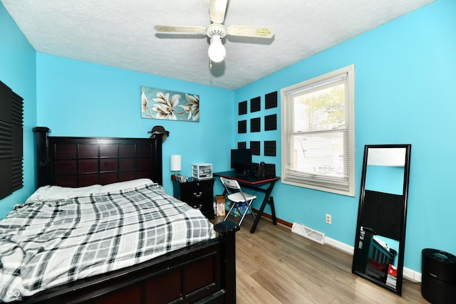 bedroom featuring a textured ceiling, light hardwood / wood-style flooring, and ceiling fan