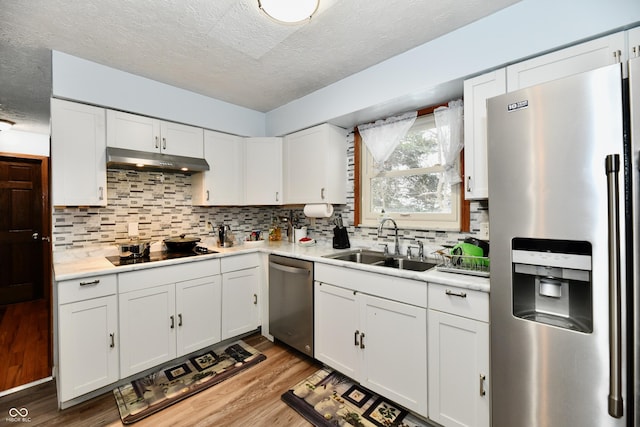 kitchen featuring white cabinets, a textured ceiling, stainless steel appliances, and sink