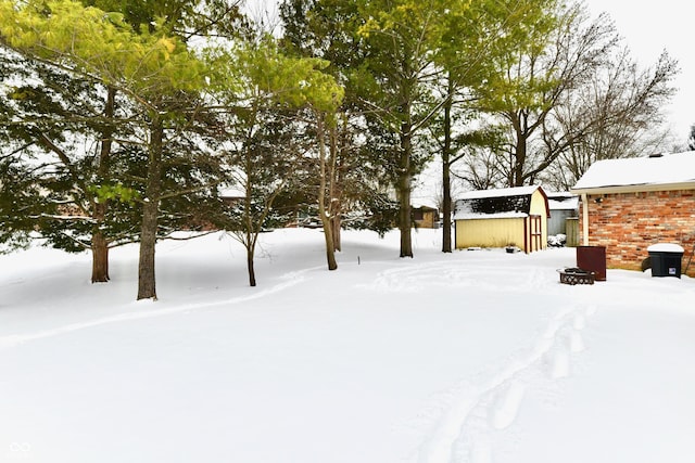 snowy yard with an outbuilding and a fire pit