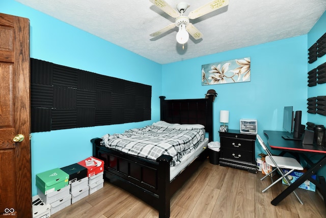 bedroom featuring ceiling fan, a textured ceiling, and light wood-type flooring