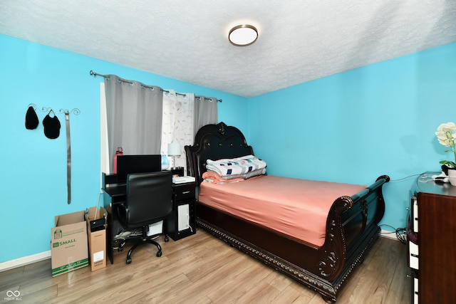 bedroom featuring hardwood / wood-style floors and a textured ceiling