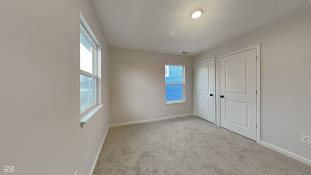 unfurnished bedroom featuring light carpet