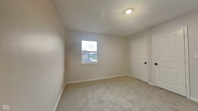 unfurnished bedroom featuring light carpet