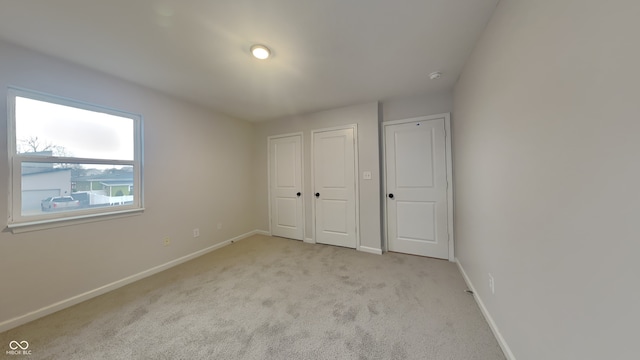 unfurnished bedroom with light colored carpet