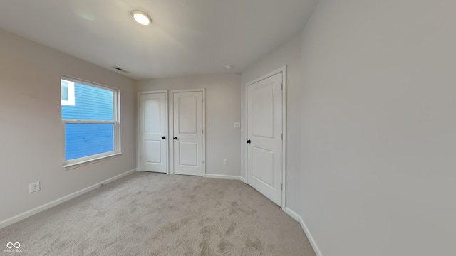 unfurnished bedroom featuring light carpet