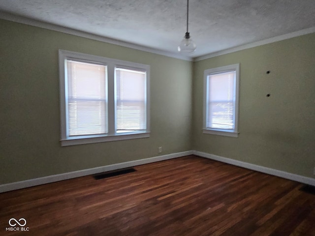 empty room featuring ornamental molding, a textured ceiling, and dark wood-type flooring