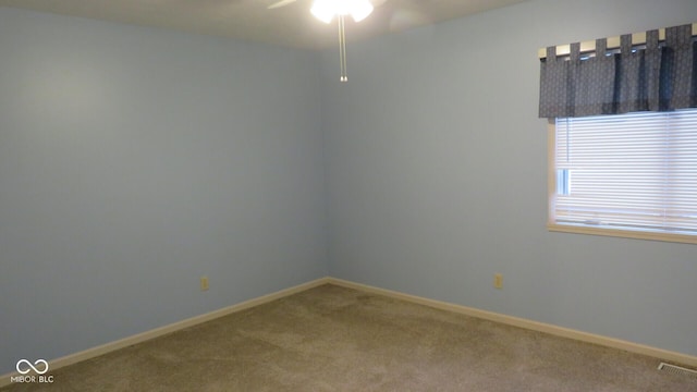 carpeted spare room with ceiling fan