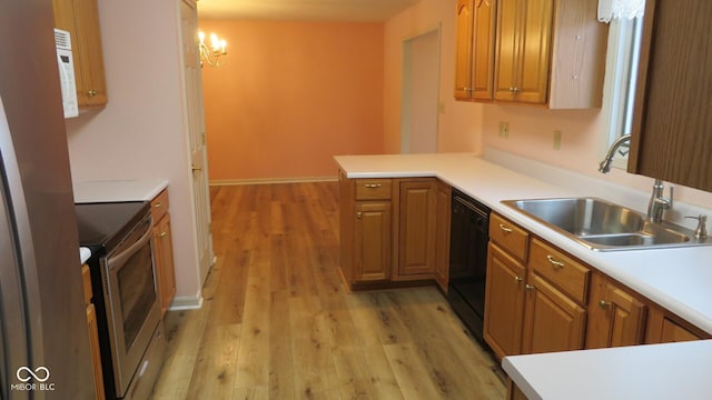 kitchen with kitchen peninsula, range with electric stovetop, hanging light fixtures, sink, and light hardwood / wood-style floors