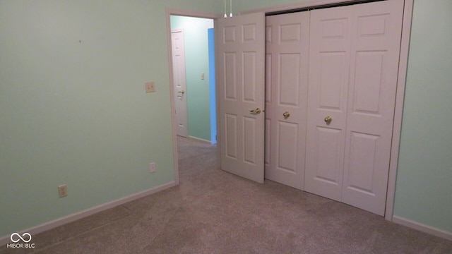 unfurnished bedroom with a closet and light carpet