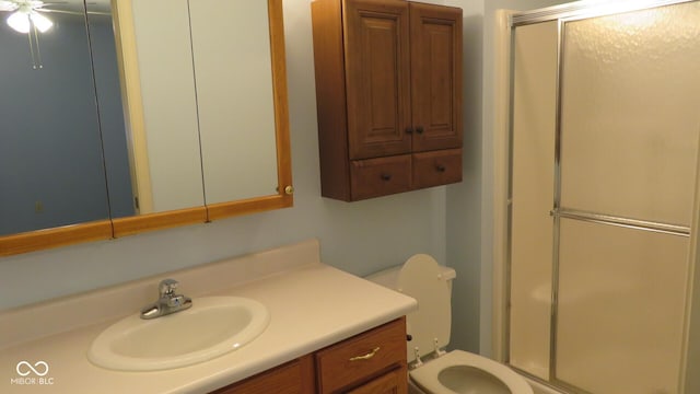 bathroom featuring a shower with door, toilet, ceiling fan, and vanity