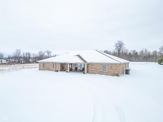 snow covered back of property with central AC