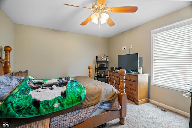 bedroom featuring multiple windows, light colored carpet, and ceiling fan