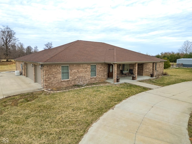 ranch-style home with driveway, roof with shingles, a front yard, a garage, and brick siding