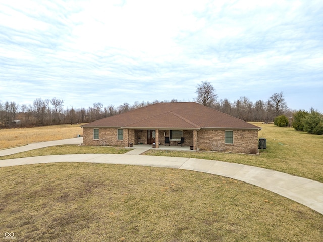 view of front of house featuring brick siding, concrete driveway, and a front yard