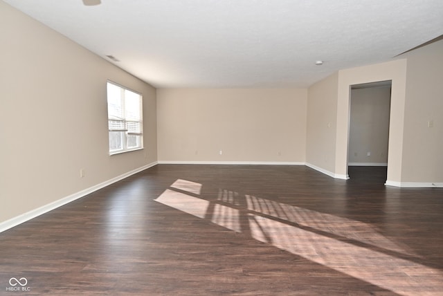 empty room with dark hardwood / wood-style flooring