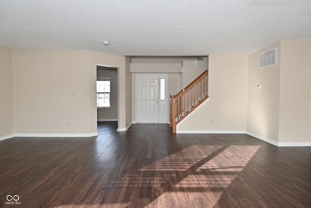 spare room with dark wood-type flooring and a textured ceiling