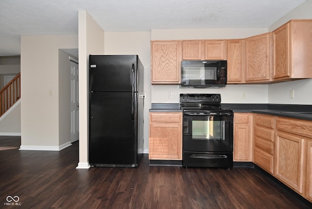 kitchen with light brown cabinetry, dark wood-type flooring, and black appliances