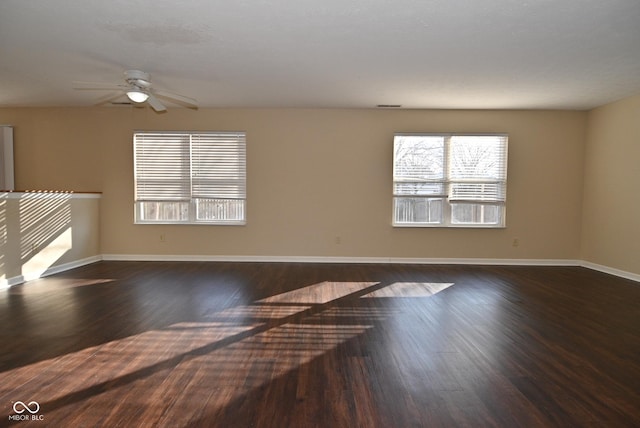 unfurnished living room with dark hardwood / wood-style floors and ceiling fan