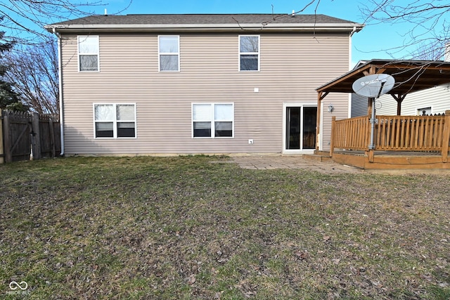 rear view of house featuring a wooden deck, a patio area, and a lawn