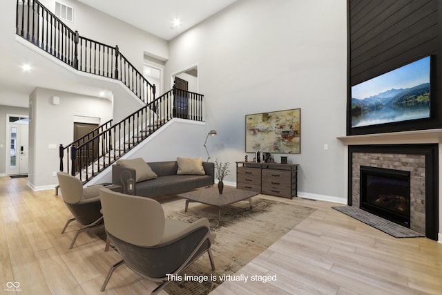 living room featuring a high ceiling and light hardwood / wood-style flooring