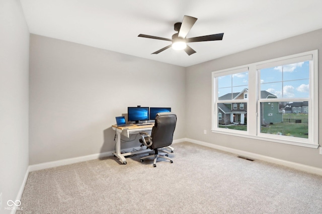 carpeted office space featuring ceiling fan