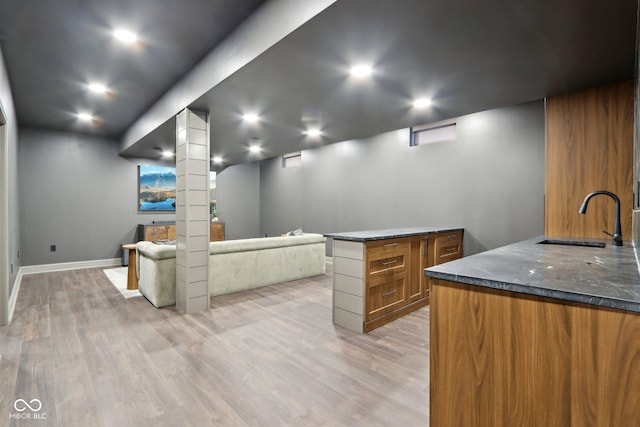 interior space with light wood-type flooring, sink, and ornate columns