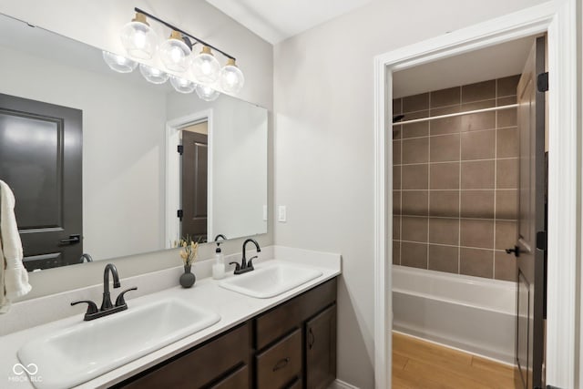 bathroom featuring tiled shower / bath, vanity, and wood-type flooring